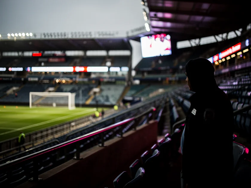 Phil Foden in Manchester City kit during a Premier League match with Pep Guardiola watching from the